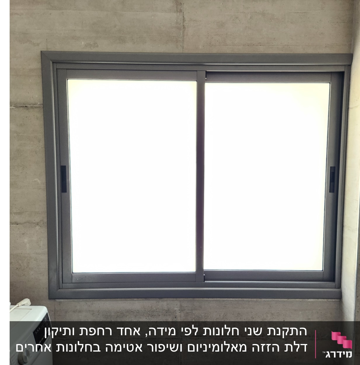 חלון אלומיניום עם מסגרת אפורה על קיר בטון